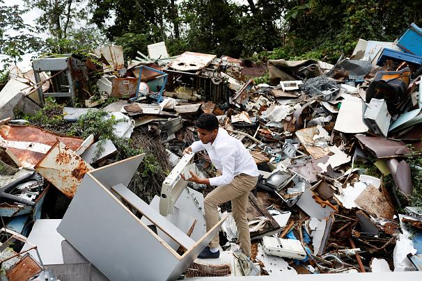 دانشجویی در کاراکاس قطعات کهنه کامپیوتر و پریتنر را از زباله‌دانی دانشگاه بیرون می‌آورد. عکس از رویترز